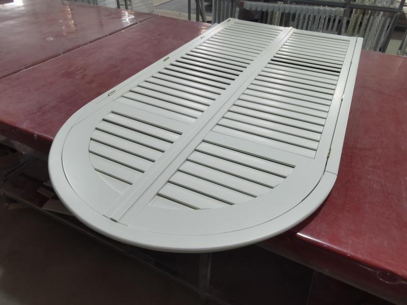Arched plantation shutter with radius top rail