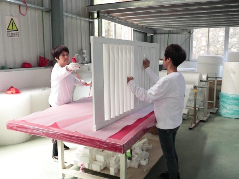 FQC inspector examining finished PVC shutter panel before protective wrapping and carton packaging